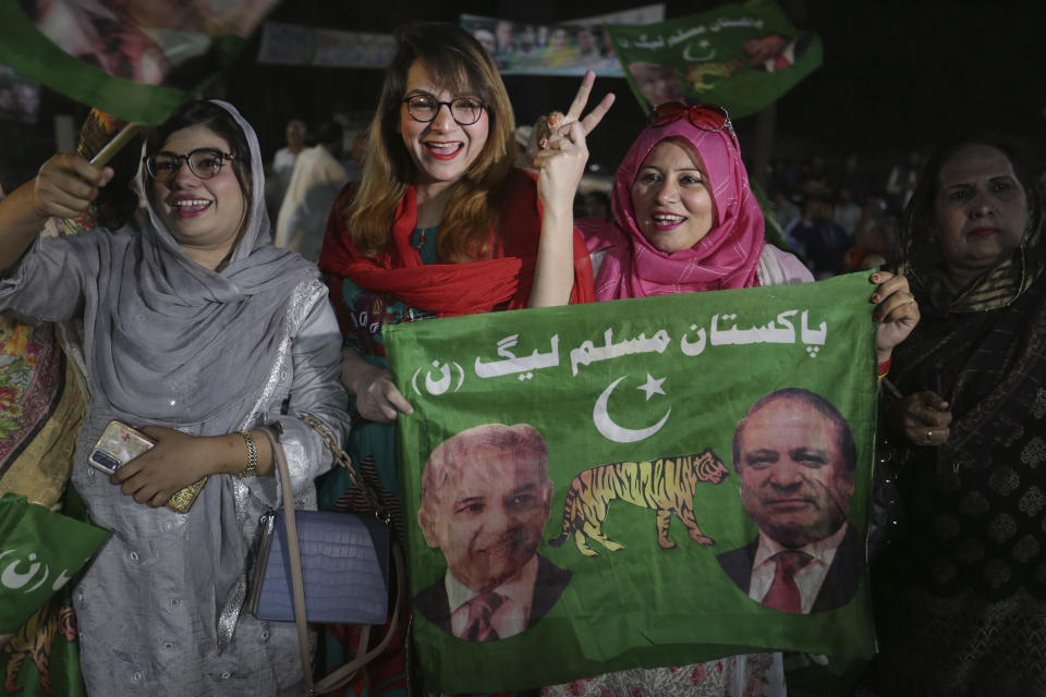 Supporters of newly elected Pakistani Prime Minister Shahbaz Sharif flash victory signs to celebrate outside their party's office, in Lahore, Pakistan, Monday, April 11, 2022. Pakistan's parliament elected opposition lawmaker Sharif as the new prime minister Monday, following a week of political turmoil that led to the weekend ouster of Premier Imran Khan. (AP Photo/K.M. Chaudary)