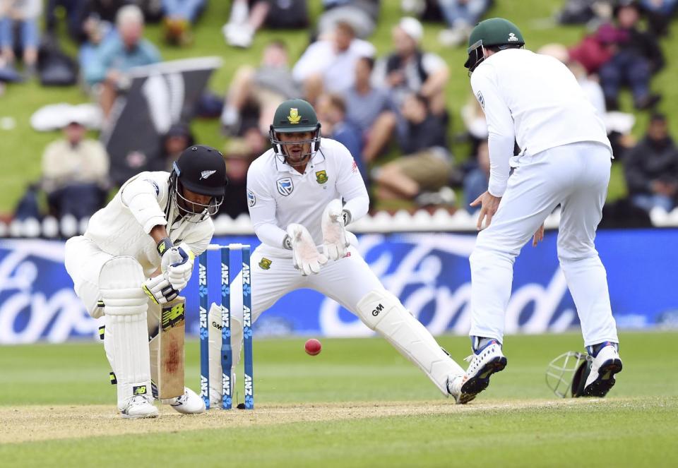 New Zealand's Henry Nicholls, left, plays defensively as South Africa's Quentin de Kock and Stephen Cook react during the second cricket test at the Basin Reserve in Wellington, New Zealand, Saturday, March 18, 2017. (Ross Setford/SNPA via AP)