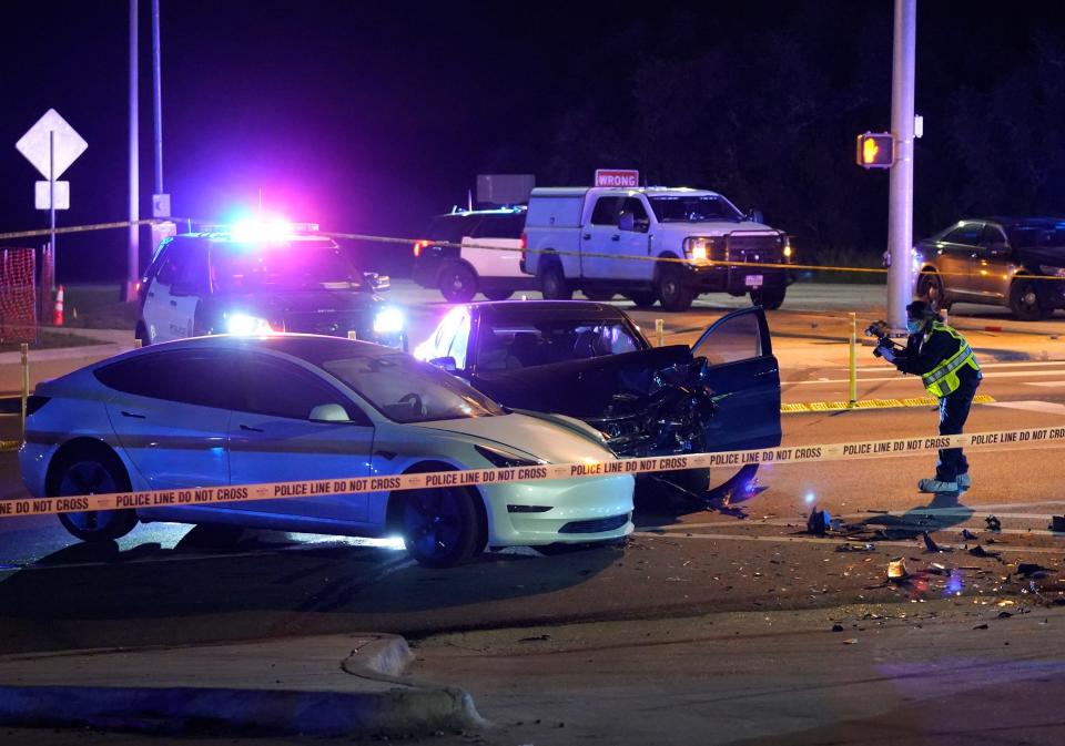 A crime scene technician photographs the crash scene at the intersection of RM 1826 and Texas 45. Police arrested Shane James Jr. there about 25 minutes after he reportedly broke into a Circle C home where police found two slain women.