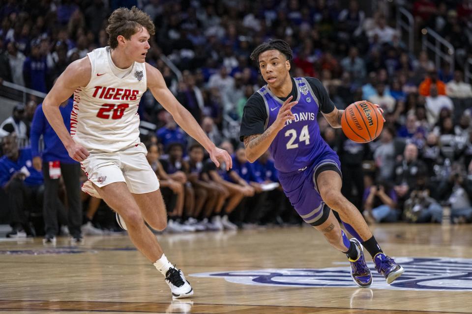 Ben Davis High School senior Karl Windham Jr. (24) drives around the defense of Fishers High School senior Parker Perdue (20) during the first half of an IHSAA class 4A state championship basketball game, Saturday, March 30, 2024, at Gainbridge Fieldhouse.