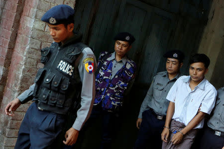 Detained Reuters journalist Kyaw Soe Oo is escorted by police after a court hearing in Yangon, Myanmar May 22, 2018. REUTERS/Ann Wang