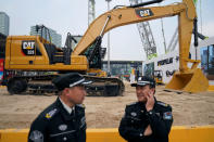 FILE PHOTO: Security guards stand in front of heavy machinery of Caterpillar at Bauma China, the International Trade Fair for Construction Machinery in Shanghai, China November 27, 2018. REUTERS/Aly Song