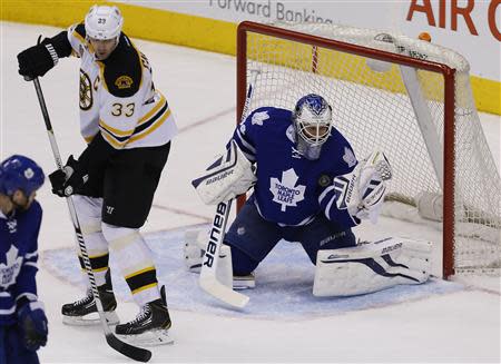 Apr 3, 2014; Toronto, Ontario, CAN; Toronto Maple Leafs goaltender James Reimer (34) makes a save on a shot tipped by Boston Bruins defenseman Zdeno Chara (33) at the Air Canada Centre. Toronto defeated Boston 4-3 in overtime. Mandatory Credit: John E. Sokolowski-USA TODAY Sports