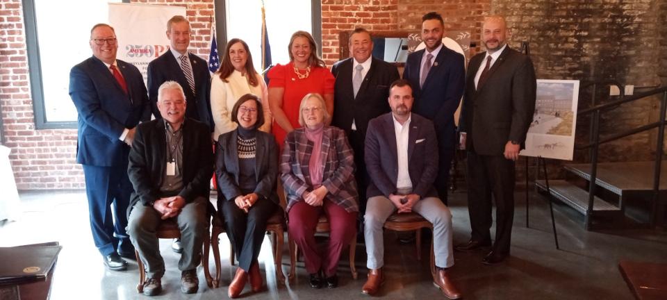 Officials met at the Boiler Room event space at the Hawley Silk Mill on Feb. 2, 2024, for the America250PA announcement naming the Silk Mill as one of several sites for a commemorative, full-scale bronze Liberty Bell. From left, seated: Wayne County Commissioners James Shook and Jocelyn Cramer; Hawley Borough Councilor Elaine Herzog; Doug Miller, field representative of state Sen. Rosemary Brown (R-40). Standing: State Rep. Joe Adams (R-139); Congressman Matt Cartwright (D-8); state Sen. Lisa Baker (R-20); Cassandra Coleman, executive director of America250PA; Justin Genzlinger, president and CEO of Settlers Hospitality, owner of the Hawley Silk Mill; Drew Popish, northeast regional director for the Office of Gov Josh .Shapiro; and state Rep. Jonathan Fritz (R-111).