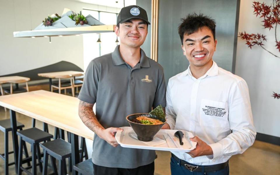Brothers Jason Lin, right, and Kevin Lin, are photographed with a bowl of tonkotsu ramen at one of two Ramen Hayashi locations in this file photo from 2022.