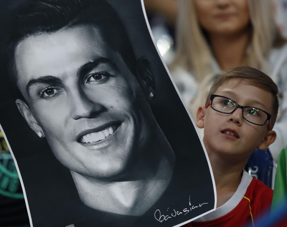 <p>Idol: A boy holds a Ronaldo portrait in Sochi. (AP) </p>