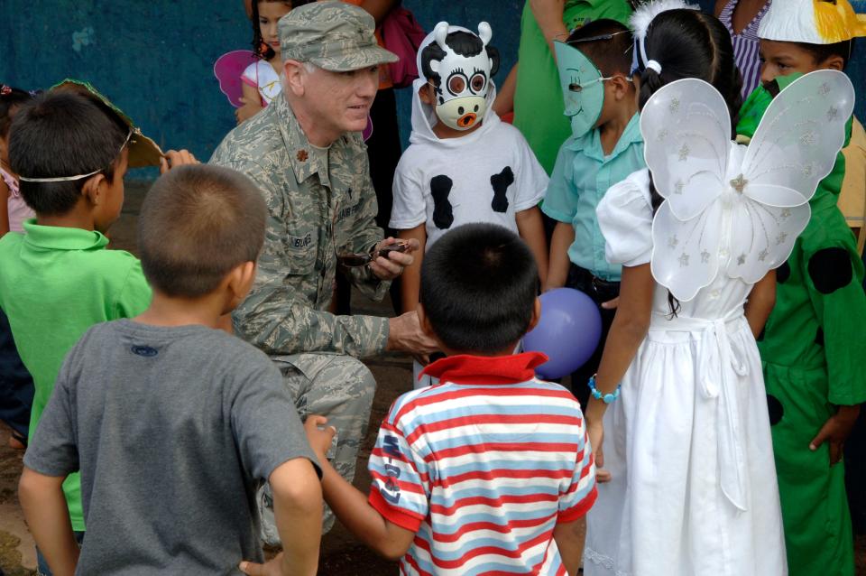 Maj. (Chaplain) Norris Burkes, 820th Expeditionary RED HORSE Squadron chaplain, talks with children from the Rio Iglesia elementary school June 24. Personnel from New Horizons Panama 2010 took time out of the construction schedule to support the school's conservation day festival.