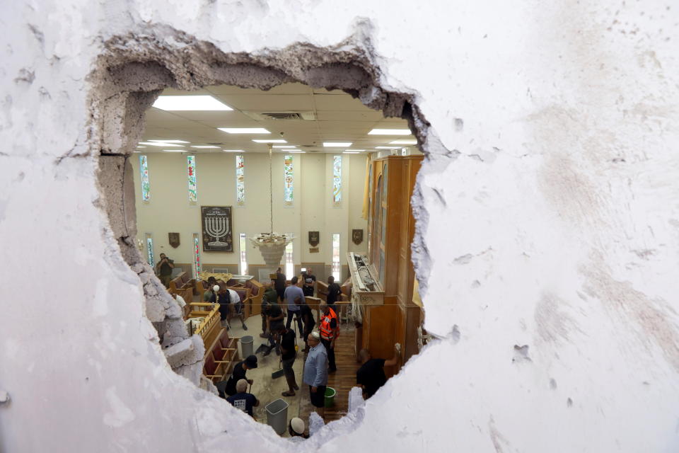 People clean inside a synagogue damaged by a rocket fired by Palestinian militants in the Gaza Strip, as Israeli-Palestinian cross-border violence continues, in Ashkelon, southern Israel, May 16, 2021. / Credit: BAZ RATNER/REUTERS