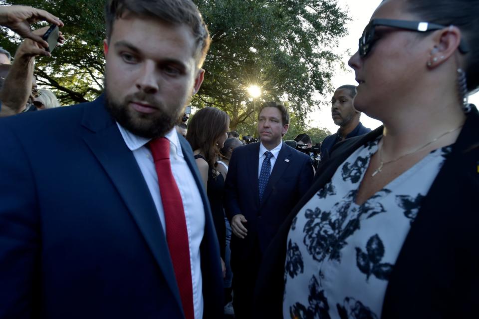 Florida Governor Ron DeSantis is escorted from the crowd by his security personnel after a prayer vigil for the Dollar General shooting victims in a racially-motivated attack in Jacksonville. 
(Credit: Bob Self/Florida Times-Union)