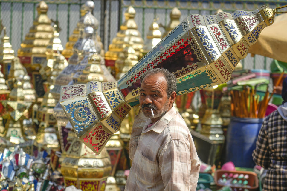 A man carries a traditional lantern in Sayyeda Zeinab market ahead of the upcoming Muslim fasting month of Ramadan, in Cairo, Egypt, Tuesday, March 21, 2023. (AP Photo/Amr Nabil)