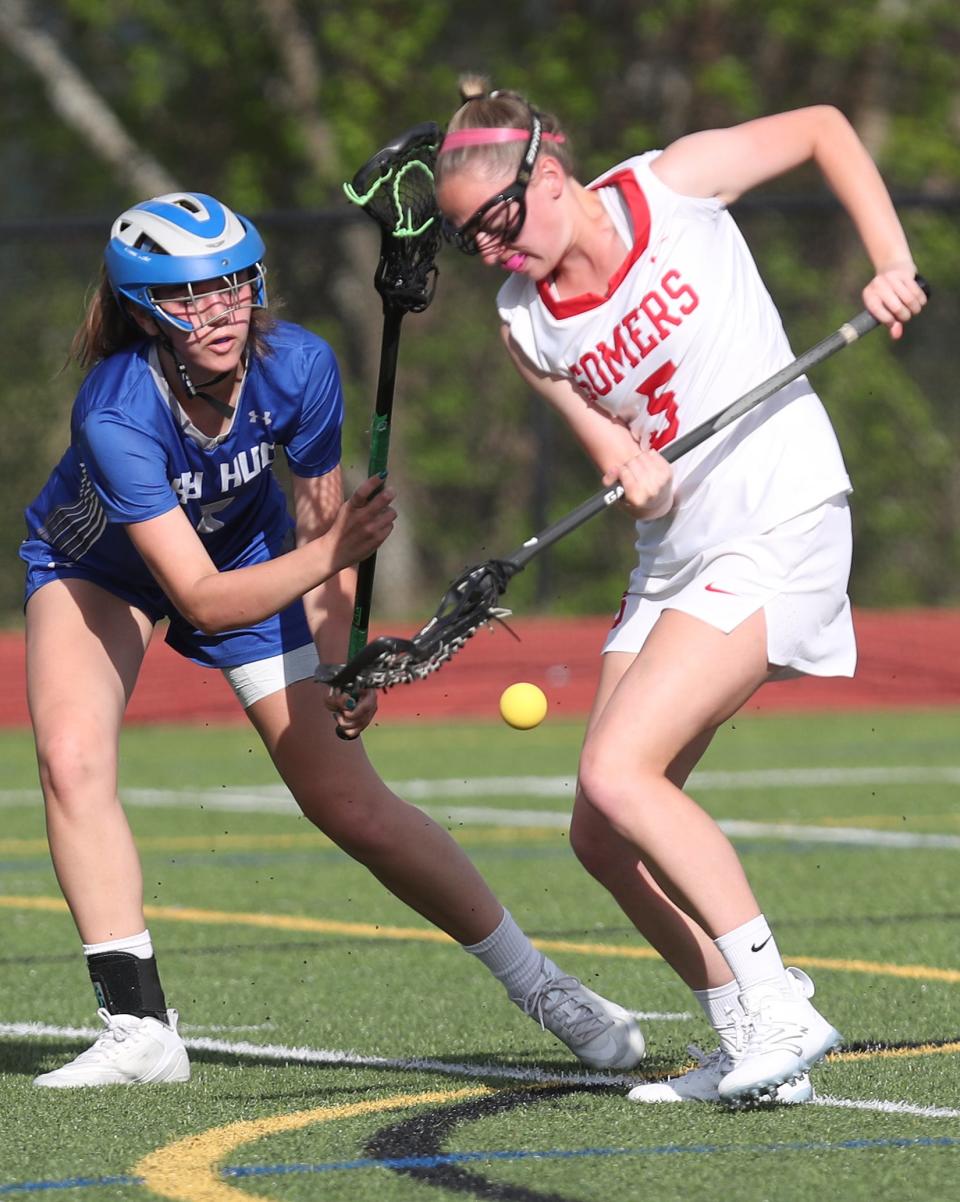 Somers'  Madelyn Lyle (5) knocks the ball away from Hen Hud's Rowan Dapson (5) during girls lacrosse action at Somers High School May 11, 2023. Somers won the game 12-7.