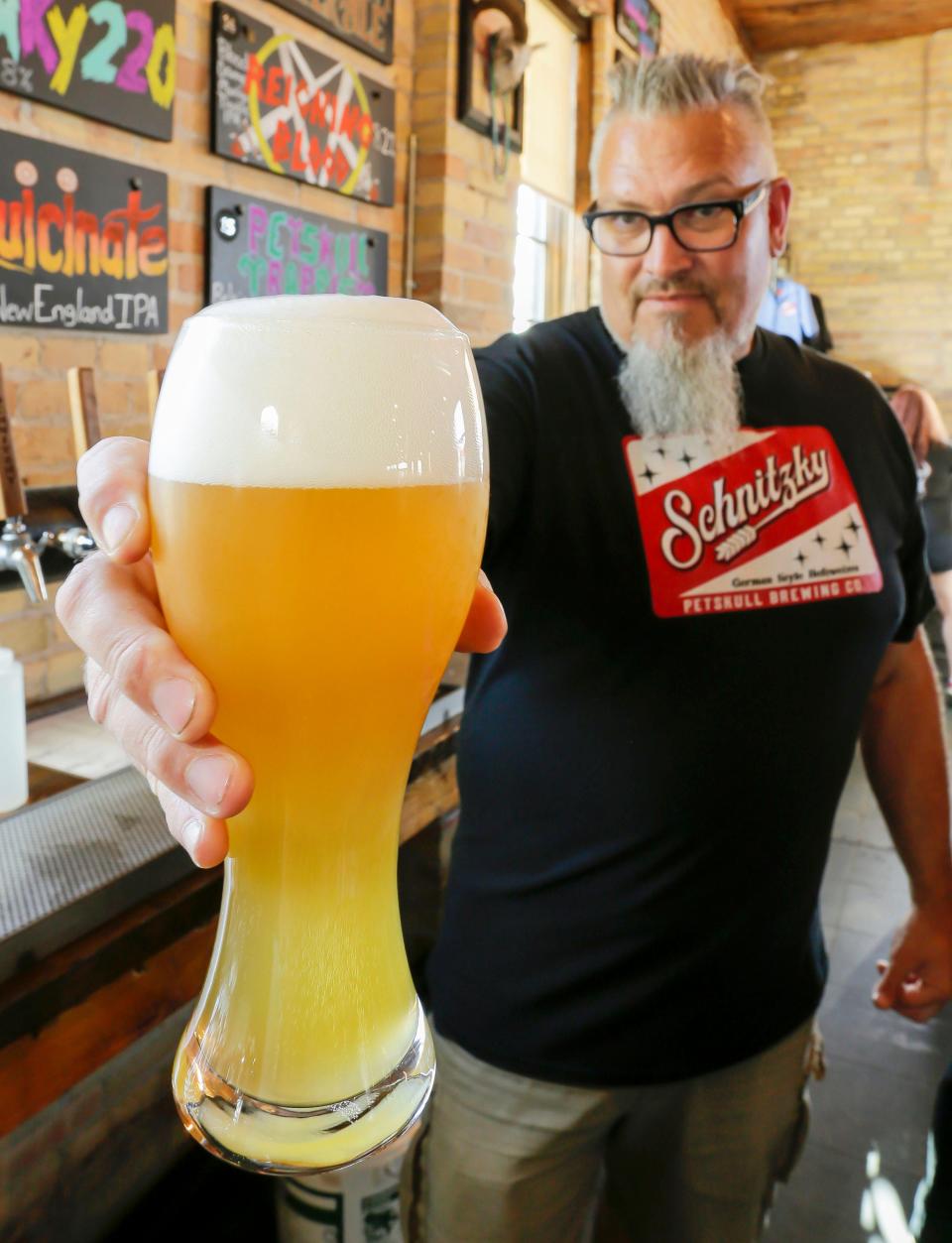 PetSkull Brewery Company owner Paul Hoffman holds a glass of Schnitzky, a German Hefeweizen style beer, Wednesday, August 31, 2022, in Manitowoc, Wis.