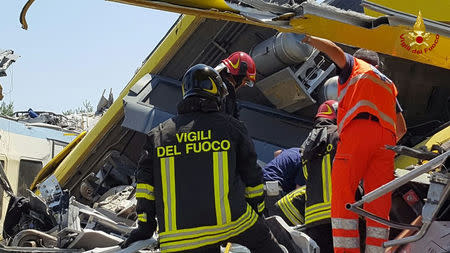 Firefighters work at the site where two passenger trains collided in the middle of an olive grove in the southern village of Corato, near Bari, Italy, in this handout picture released by Italian Firefighters July 12, 2016. Italian Firefighters/Handout via Reuters
