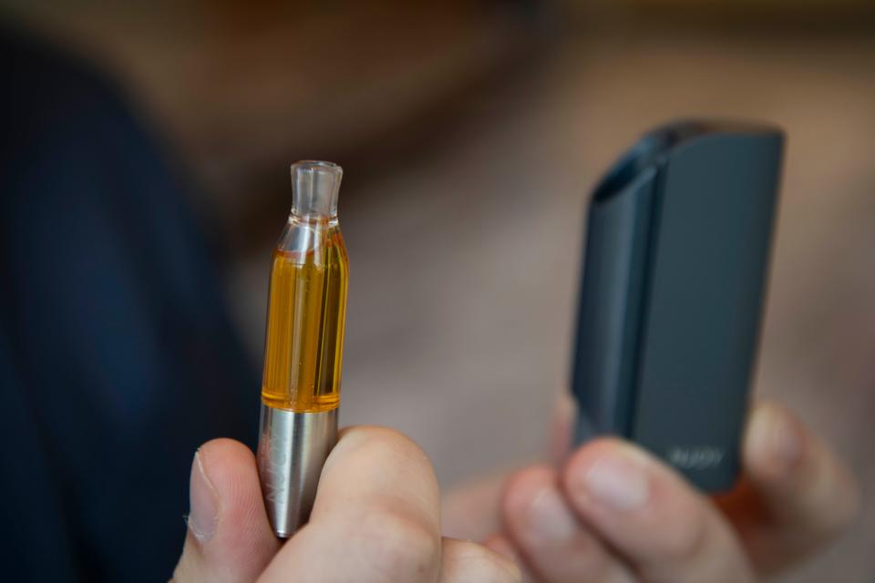 Gregory Conley, founder of the American Vaping Association, shows the tobacco vaping cartridge he uses to highlight the difference between it and THC vape pens. The e-liquid is thinner than THC oil.