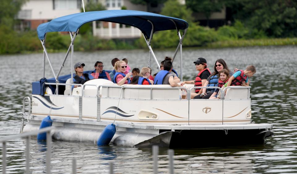 A group of visitors take a leisurely pontoon boat ride during Summerfest at Sippo Lake Park.