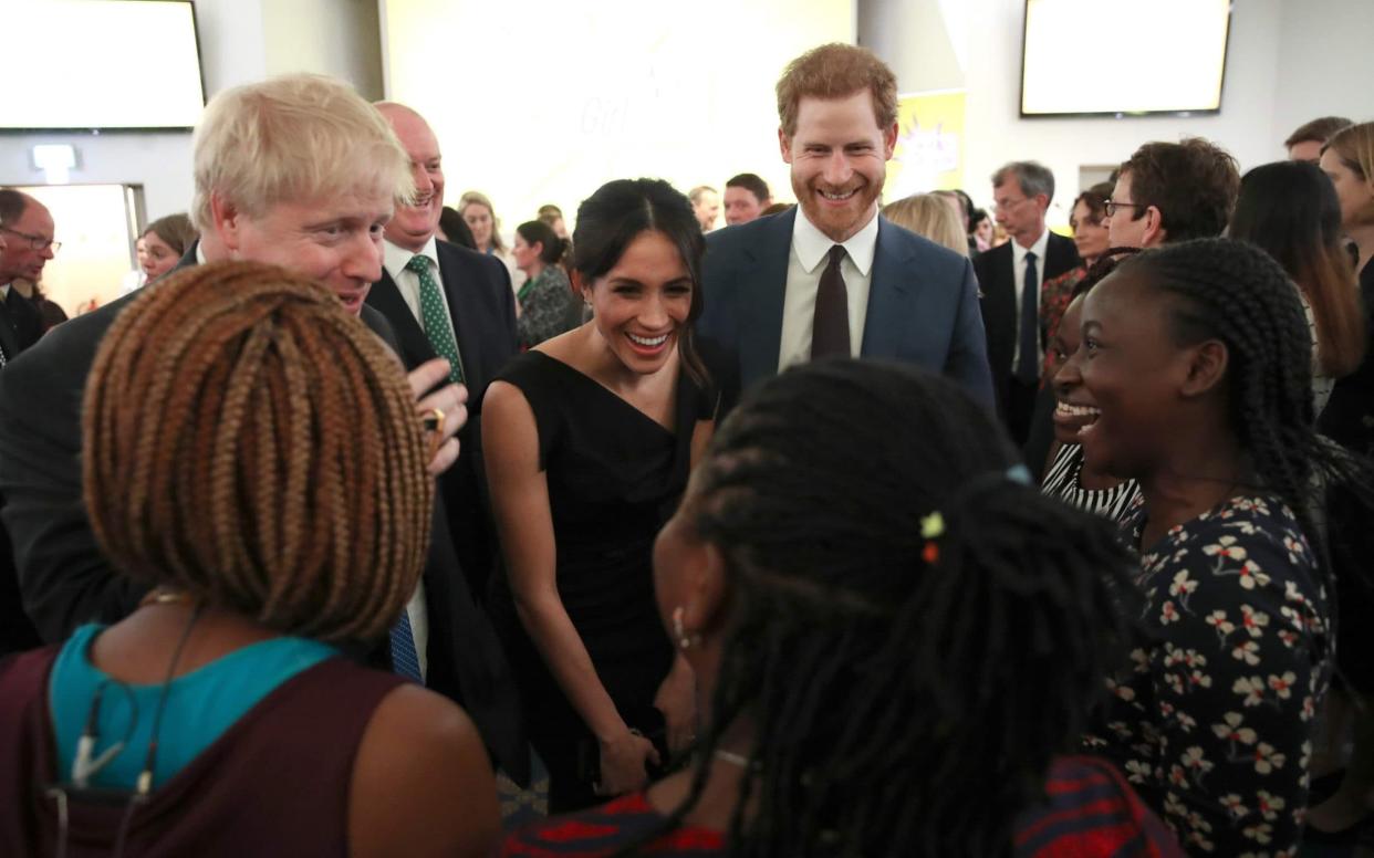 Boris Johnson, Meghan and Prince Harry in happier times - AFP