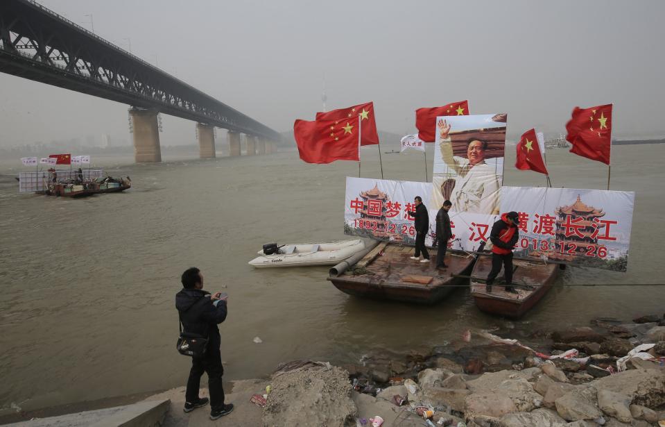 Boats get ready to lead the winter swimmers ahead of a swimming exercise in the Yangtze River to celebrate the 120th birth anniversary of Mao, on a hazy day in Wuhan