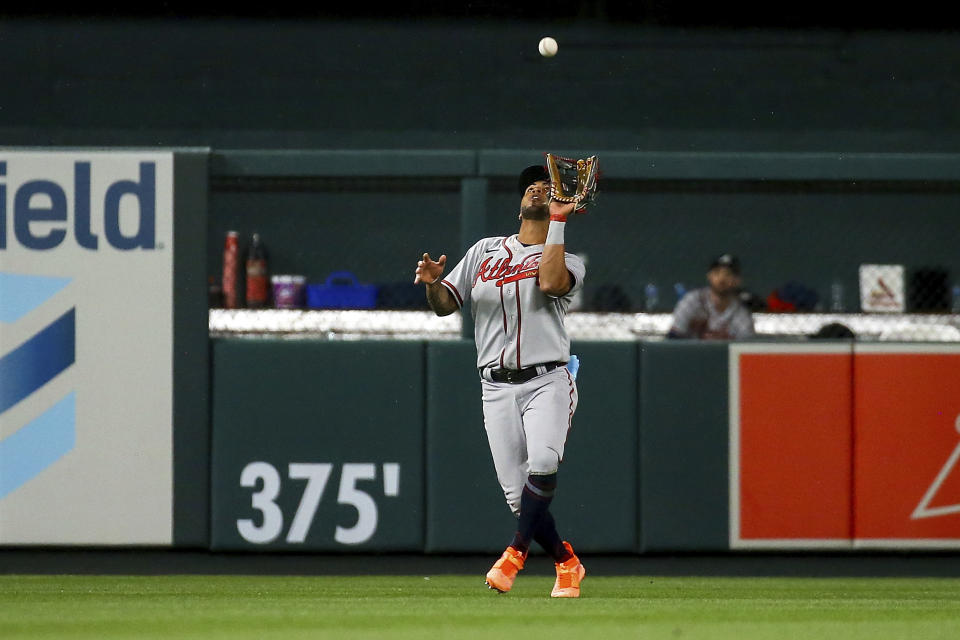 Atlanta Braves left fielder Eddie Rosario (8) catches a fly ball for an out against St. Louis Cardinals' Dylan Carlson during the eighth inning of a baseball game Tuesday, April 4, 2023, in St. Louis. (AP Photo/Scott Kane)