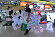 A salesperson carries an OPPO smartphone banner of Indonesia's filmstar Chelsea Islan at ITC Roxymas shopping mall in Jakarta, Indonesia, September 22, 2016. REUTERS/Beawiharta