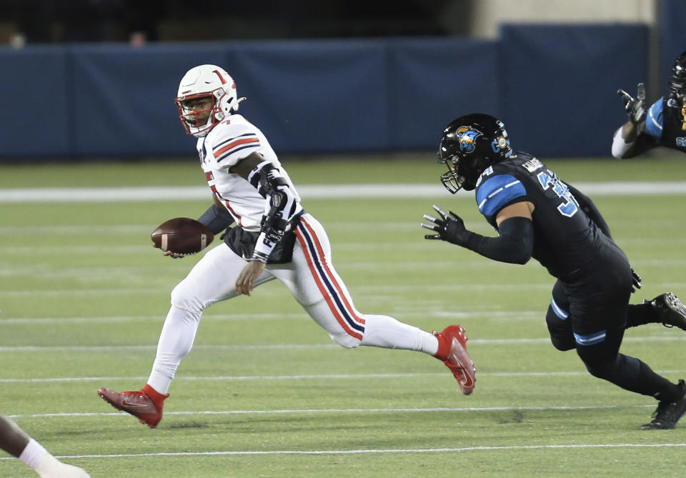 Liberty quarterback Malik Willis (7) runs upfield past Coastal Carolina linebacker Teddy Gallagher (34) during the first half of the Cure Bowl NCAA college football game Saturday, Dec. 26, 2020, in Orlando, Fla. (AP Photo/Matt Stamey)