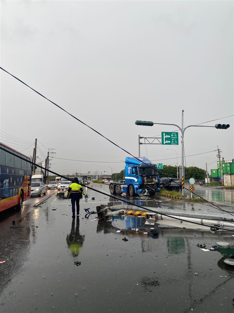 聯結車疑似因天雨路滑，失控衝撞分隔島，撞斷燈號桿釀1傷。（圖／翻攝畫面）