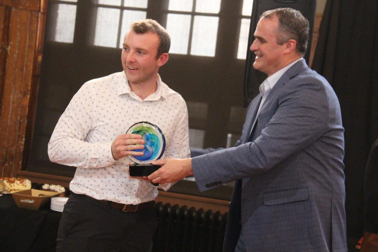 Shawn Kenney presents the Spirit of Perry Business of the Year Award to Jackson VanKirk of Progressive Foundry during the Perry Chamber's annual dinner on Tuesday, April 4, 2023, at La Poste.