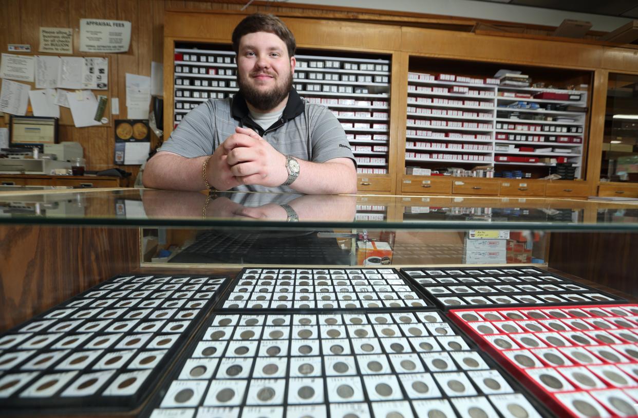 Seth Karn, the third generation of Karns to work at Allen's, sits behind one of the displays at the store May 27.