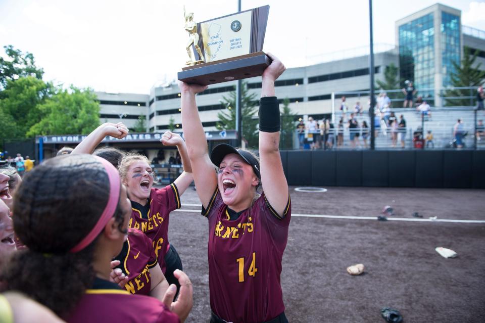 Haddon Heights' Maddy Clark hoists the trophy and celebrates with her teammates after Haddon Heights defeated Hanover Park, 4-0, in the Group 2 softball championship game played at Ivy Hill Park in Newark on Saturday, June 4, 2022. 