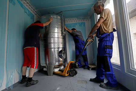 Workers of Smart Brewery Well Service move a brew kattle inside of a standard shipping container in the village of Chlum near the town of Trebic, Czech Republic, September 2, 2017. Picture taken September 2, 2017. REUTERS/David W Cerny