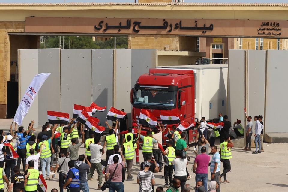 Egyptian aid workers watch as a truck crosses back into Egypt through the Rafah border crossing with Gaza on 21 October, 2023 (AFP via Getty Images)