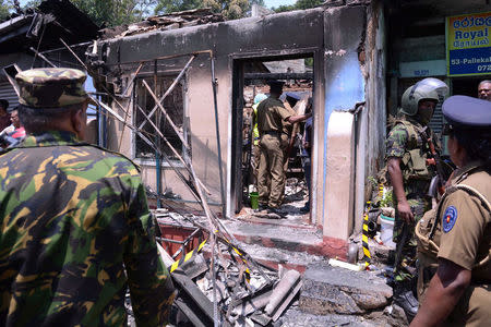 Sri Lanka's Special Task Force and Police officers stand guard near a burnt house after a clash between two communities in Digana, central district of Kandy, Sri Lanka March 6, 2018. REUTERS/Stringer
