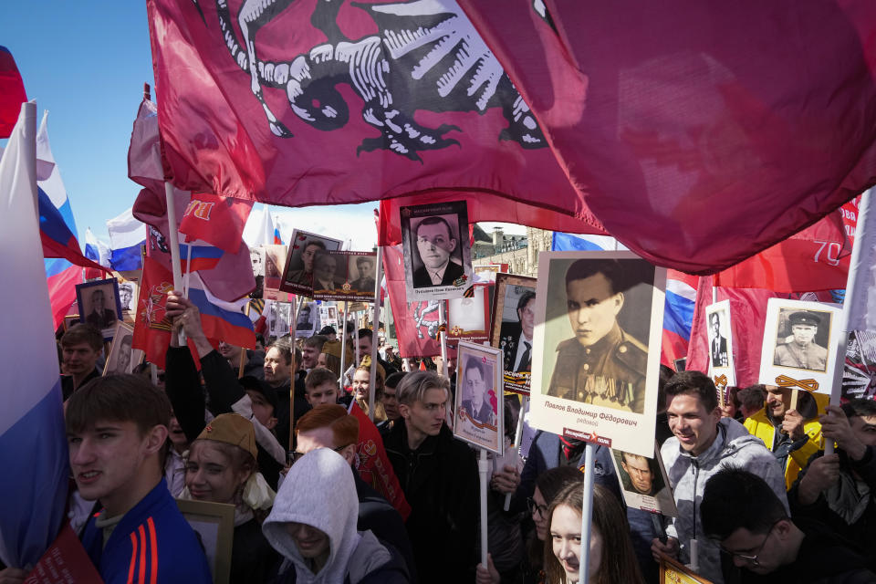 People carry portraits of relatives who fought in World War II, during the Immortal Regiment march through Red Square marking the 77th anniversary of the end of World War II, in Moscow, Russia, Monday, May 9, 2022. (AP Photo/Alexander Zemlianichenko)