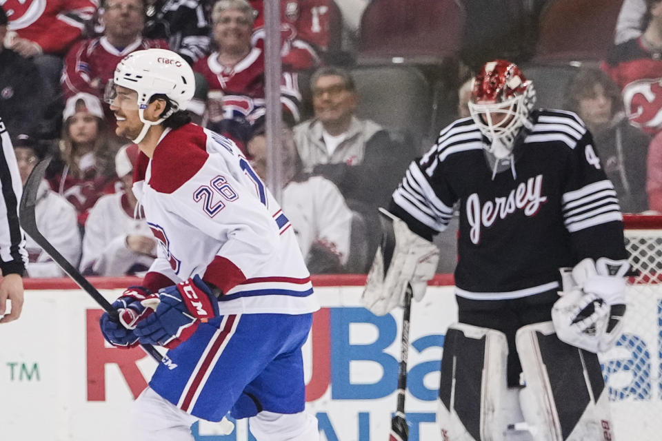 Montreal Canadiens' Johnathan Kovacevic (26) smiles after scoring a goal during the second period of an NHL hockey game as New Jersey Devils goaltender Vitek Vanecek (41) reacts Tuesday, Feb. 21, 2023, in Newark, N.J. (AP Photo/Frank Franklin II)