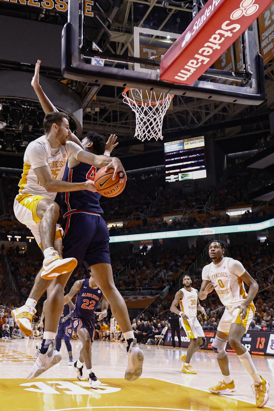 Tennessee guard Santiago Vescovi (25) passes the ball around Auburn center Dylan Cardwell (44) during the first half of an NCAA college basketball game Saturday, Feb. 26, 2022, in Knoxville, Tenn. (AP Photo/Wade Payne)