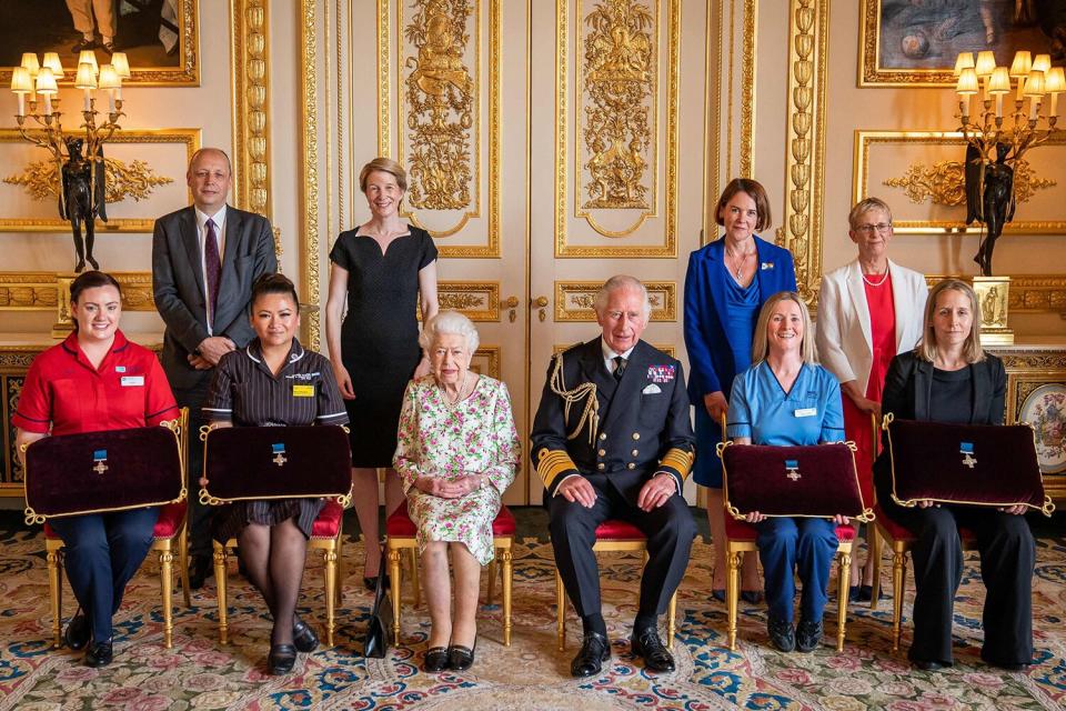 Queen Elizabeth II (5L) and Britain's Prince Charles, Prince of Wales (5R) pose with (back row LtoR) Peter May, Permanent Secretary at Britain's Department of Health, Amanda Pritchard, Chief Executive NHS England, Caroline Lamb, Chief Executive NHS Scotland, and Judith Paget, Chief Executive NHS Wales as (front row LtoR) Sister Joanna Hogg, Royal Victoria Hospital Emergency Department, May Parsons, Modern Matron at University Hospital Coventry and Warkwickshire, Eleanor Grant, Palliative Care Nurse, Specialist University Hospital Wishaw, NHS Lanarkshire, and Dr Ami Jones, Intensive Care Consultant, Aneurin Bevan University Health Board sit with George Cross medals awarded to Britian's National Health Service (NHS) Audience at Windsor Castle