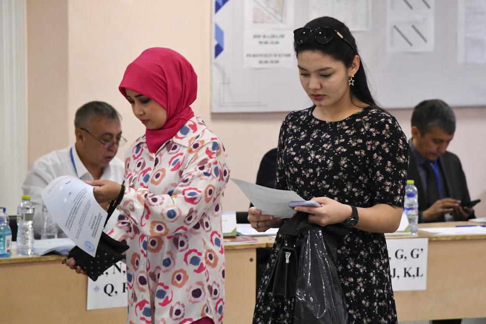 Two women hold their ballots at a polling station during a referendum in Tashkent, Uzbekistan, Sunday, April 30, 2023. Voters in Uzbekistan are casting ballots in a referendum on a revised constitution that promises human rights reforms. But the reforms being voted on Sunday also would allow the country's president to stay in office until 2040. (AP Photo)