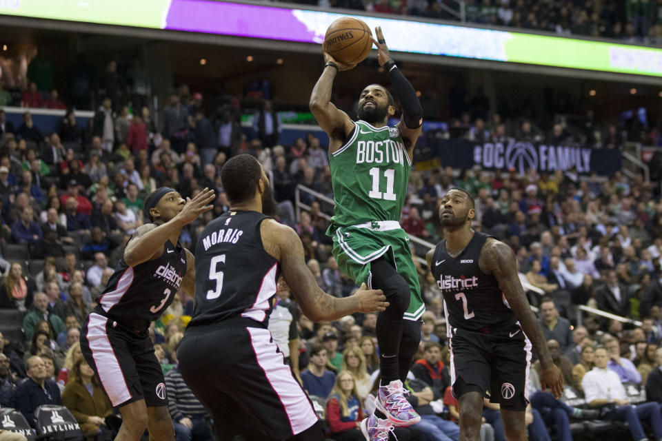 Boston Celtics guard Kyrie Irving (11) shoots between Washington Wizards guard Bradley Beal (3), forward Markieff Morris (5), and guard John Wall (2) during the overtime period of an NBA basketball game, Wednesday, Dec. 12, 2018, in Washington. The Celtics won 130-125. (AP Photo/Alex Brandon)