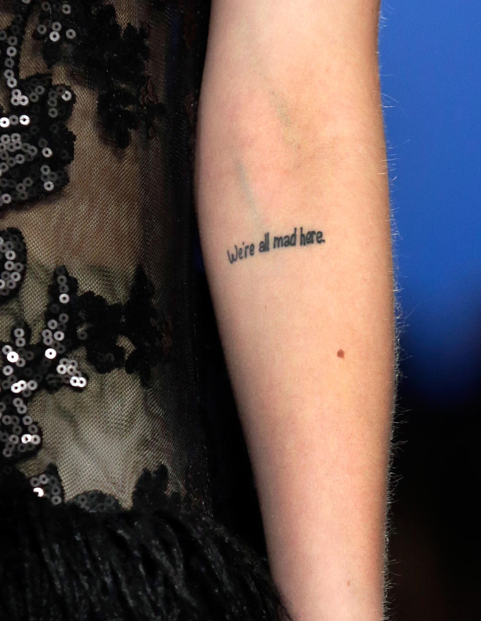 A model has a tattoo stating "We're all mad here" on her inner arm as the Tadashi Shoji Fall 2013 collection is modeled during Fashion Week in New York, Thursday, Feb. 7, 2013. (AP Photo/Richard Drew)