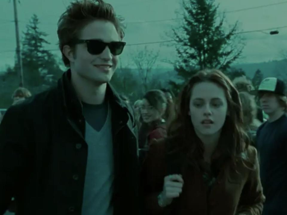 Edward wearing sun glasses walking with Bella in "Twilight"