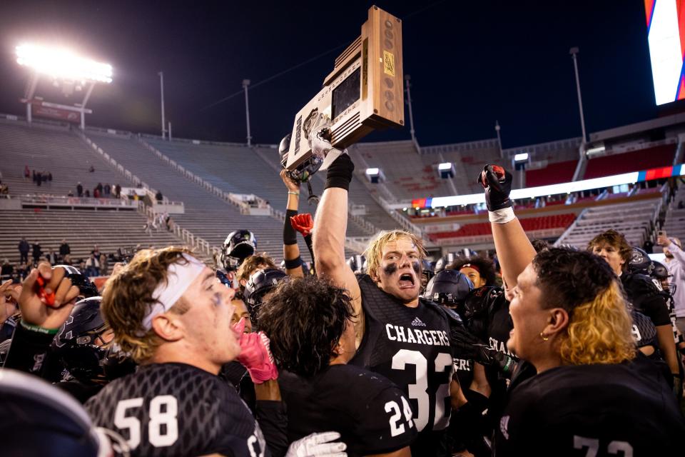Corner Canyon’s Kash Dillon hoists the trophy as the team celebrates beating Skyridge in the 6A high school football championship at Rice-Eccles Stadium in Salt Lake City on Friday, Nov. 17, 2023. | Spenser Heaps, Deseret News