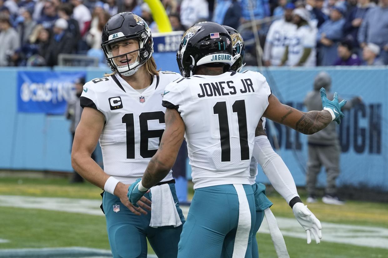 Jacksonville Jaguars quarterback Trevor Lawrence (16) and wide receiver Marvin Jones Jr. (11) celebrate after a touchdown by tight end Evan Engram during the first half of an NFL football game against the Tennessee Titans Sunday, Dec. 11, 2022, in Nashville, Tenn. (AP Photo/Chris Carlson)