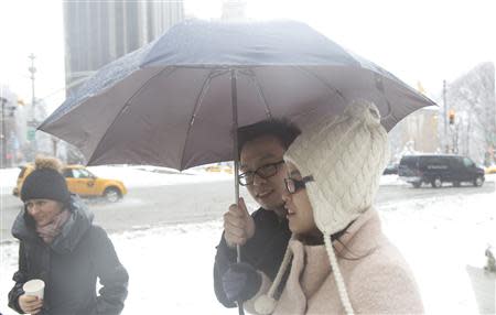 People walk under an umbrella in the rain in the Manhattan borough of New York February 5, 2014. REUTERS/Carlo Allegri