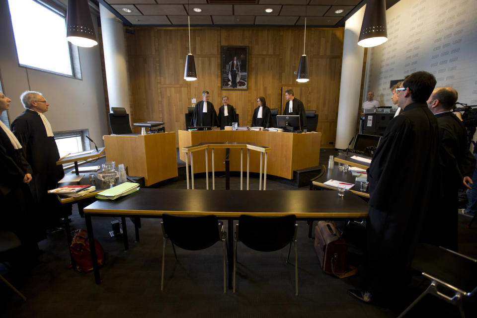 Judges, rear, enter a courtroom in The Hague, Netherlands, Monday, April 7, 2014, as defense lawyer Gert-Jan Houtzagers, left, for the Dutch state and lawyers for the plaintiffs, right, stand up. Mothers and widows of men murdered in Europe's worst massacre since World War II are suing the Dutch government for failing to protect their husbands and sons during the 1995 Srebrenica genocide. The civil case starting Monday in the courtroom focuses on the failure of Dutch troops serving as United Nations peacekeepers to protect Muslim men in the protected enclave in eastern Bosnia from rebel Serbs who overran the town and killed some 8,000 men and boys. (AP Photo/Peter Dejong)