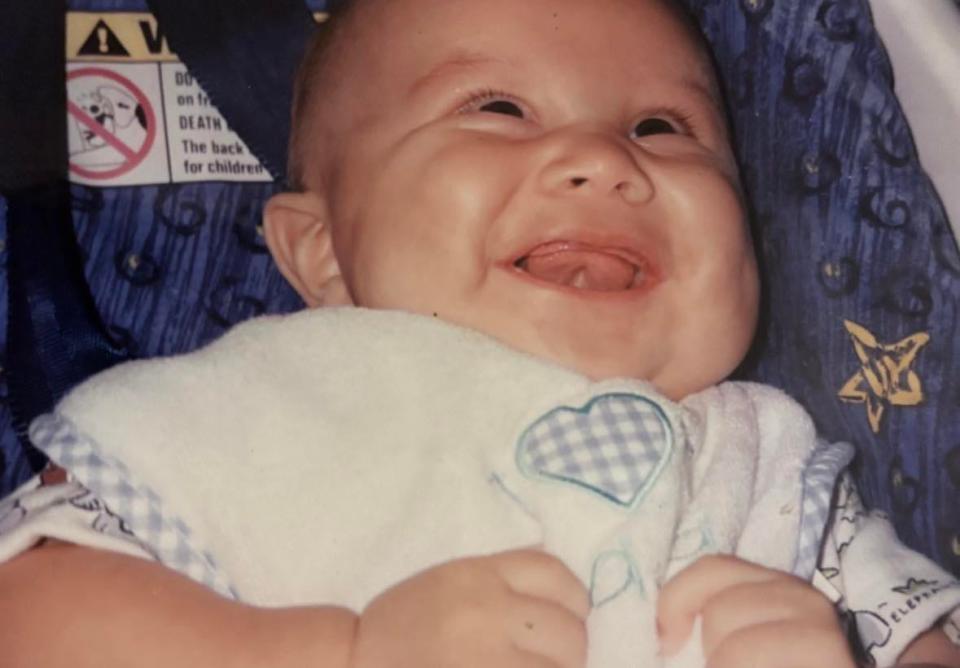 Tristan Bustos is pictured around 4 months old in 1999. Bustos was a happy and healthy baby and the star of the family from the beginning, their mother Amy Nochebuena said.
