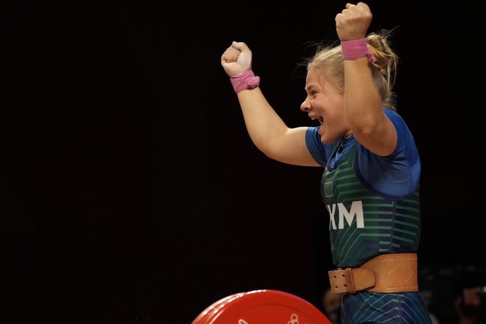 Polina Guryeva of Turkmekistan celebrates after the last lift as she competes in the women's 59kg weightlifting event, at the 2020 Summer Olympics, Tuesday, July 27, 2021, in Tokyo, Japan. (AP Photo/Luca Bruno)