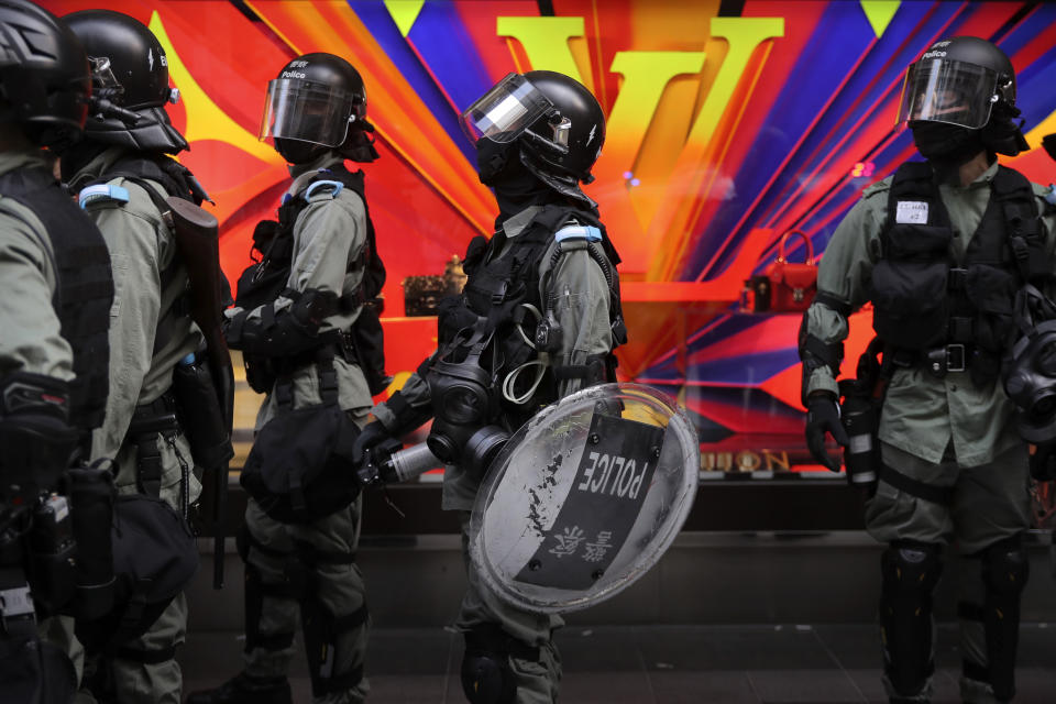 Riot police gather near a Louis Vuitton store during a demonstration in the financial district in Hong Kong, Wednesday, Nov. 20, 2019. Hong Kong schools reopened Wednesday after a six-day shutdown but students and commuters faced transit disruptions as the last protesters remained holed up on a university campus. (AP Photo/Kin Cheung)