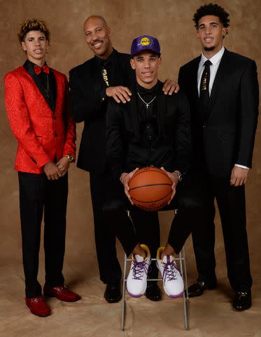 <p>Jennifer Pottheiser/NBAE/Getty</p> LaVar Ball, LaMelo Ball and LiAngelo Ball pose for a portrait with Lonzo Ball after being drafted number two overall to the Los Angeles Lakers during the 2017 NBA Draft on June 22, 2017.