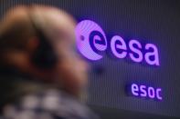 The European Space Agency (ESA) logo is pictured as a flight engineer works in the main control room of European Space Operations Centre (ESOC) in Darmstadt, during the Rosetta mission, January 20, 2014. Comet-chasing spacecraft Rosetta woke from nearly three years of hibernation on Monday to complete a decade-long deep space mission that scientists hope will help unlock some of the secrets of the solar system. Rosetta, which was launched by the ESA in 2004, is due to rendezvous with comet 67P/Churyumov-Gerasimenko and land a probe on it this year in an unprecedented manoeuvre. (REUTERS/Ralph Orlowski)