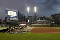 Grounds crew pull out the tarp as rain falls during the fifth inning of a baseball game between the Atlanta Braves and the St. Louis Cardinals Monday, July 4, 2022, in Atlanta. (AP Photo/Butch Dill)