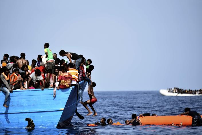 Migrants wait to be rescued by members of Proactiva Open Arms NGO as they drift in the Mediterranean Sea, some 12 nautical miles north of Libya, on October 4, 2016. At least 1,800 migrants were rescued off the Libyan coast, the Italian coastguard announced, adding that similar operations were underway around 15 other overloaded vessels. / AFP / ARIS MESSINIS        (Photo credit should read ARIS MESSINIS/AFP/Getty Images)